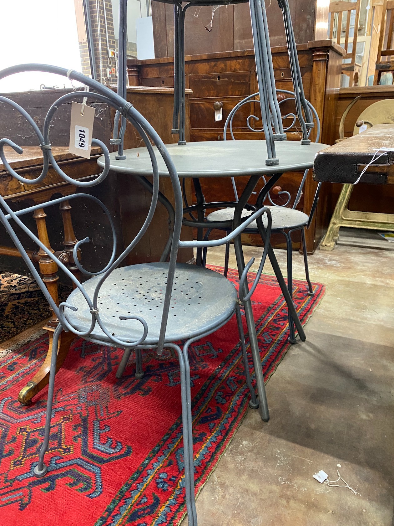 A circular wrought iron garden table, diameter 70cm, height 71cm together with four wrought iron garden chairs